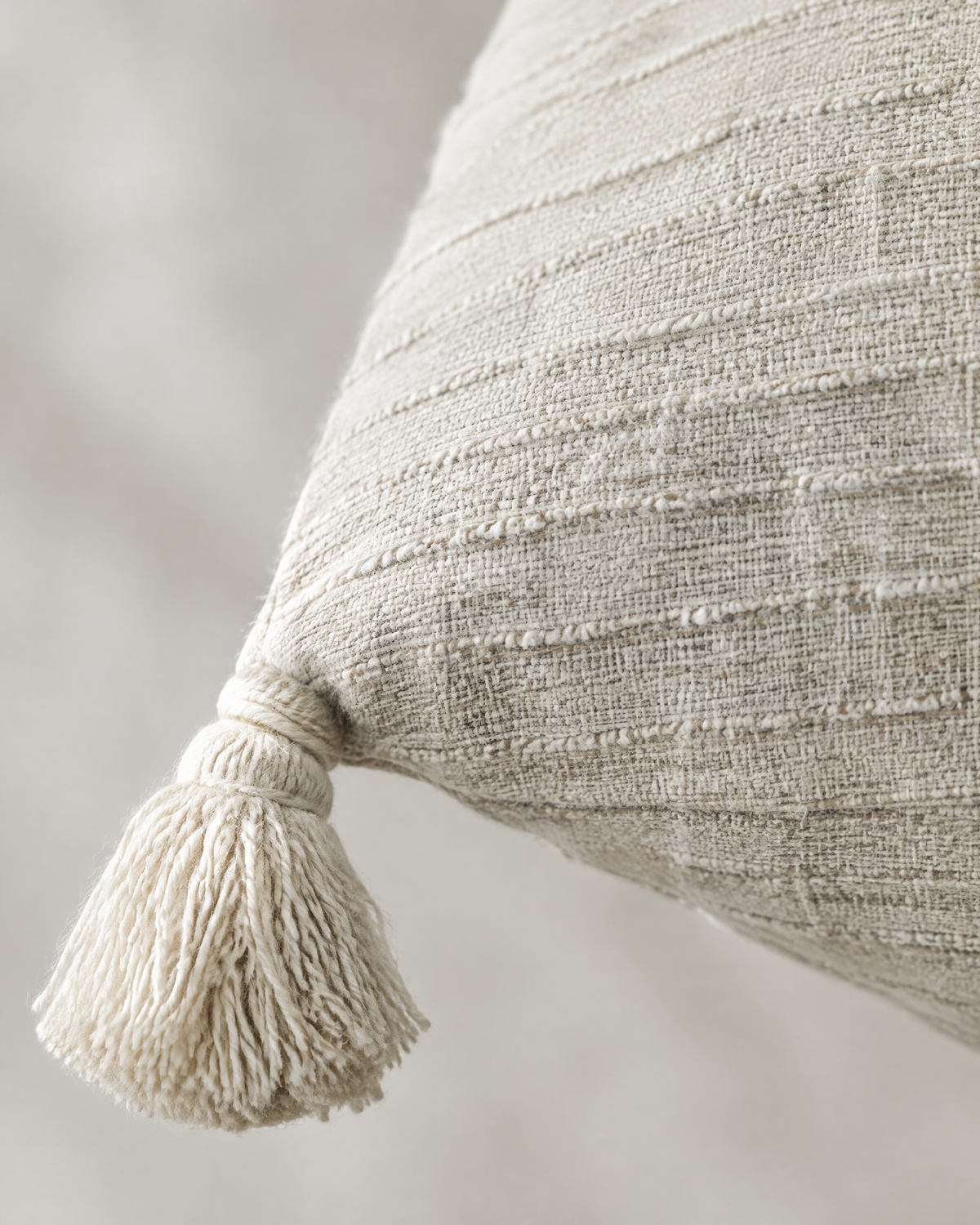 Close-up of ivory textured weave with corner tassel