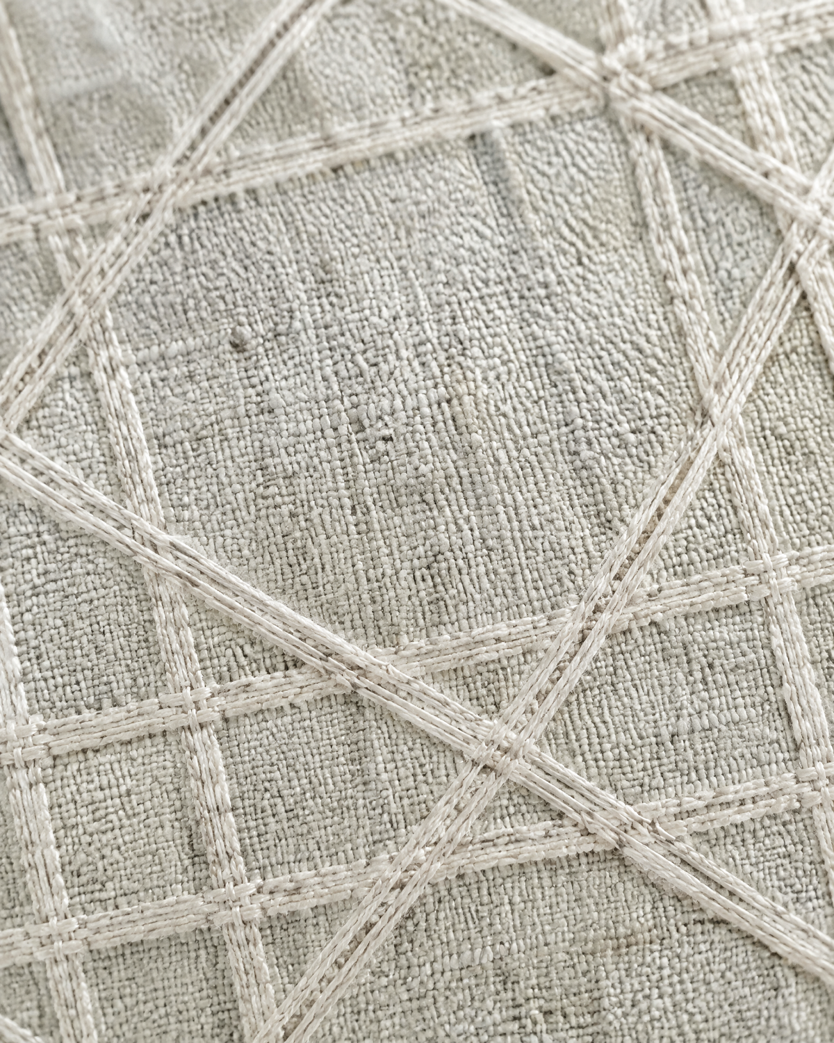 Macro close-up of the mint grey lattice, a woven ivory cane lattice on pale greige linen