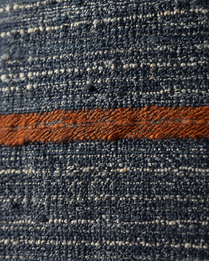 Macro close-up of a slubby rust stripe across heathered navy hemp-cotton weave