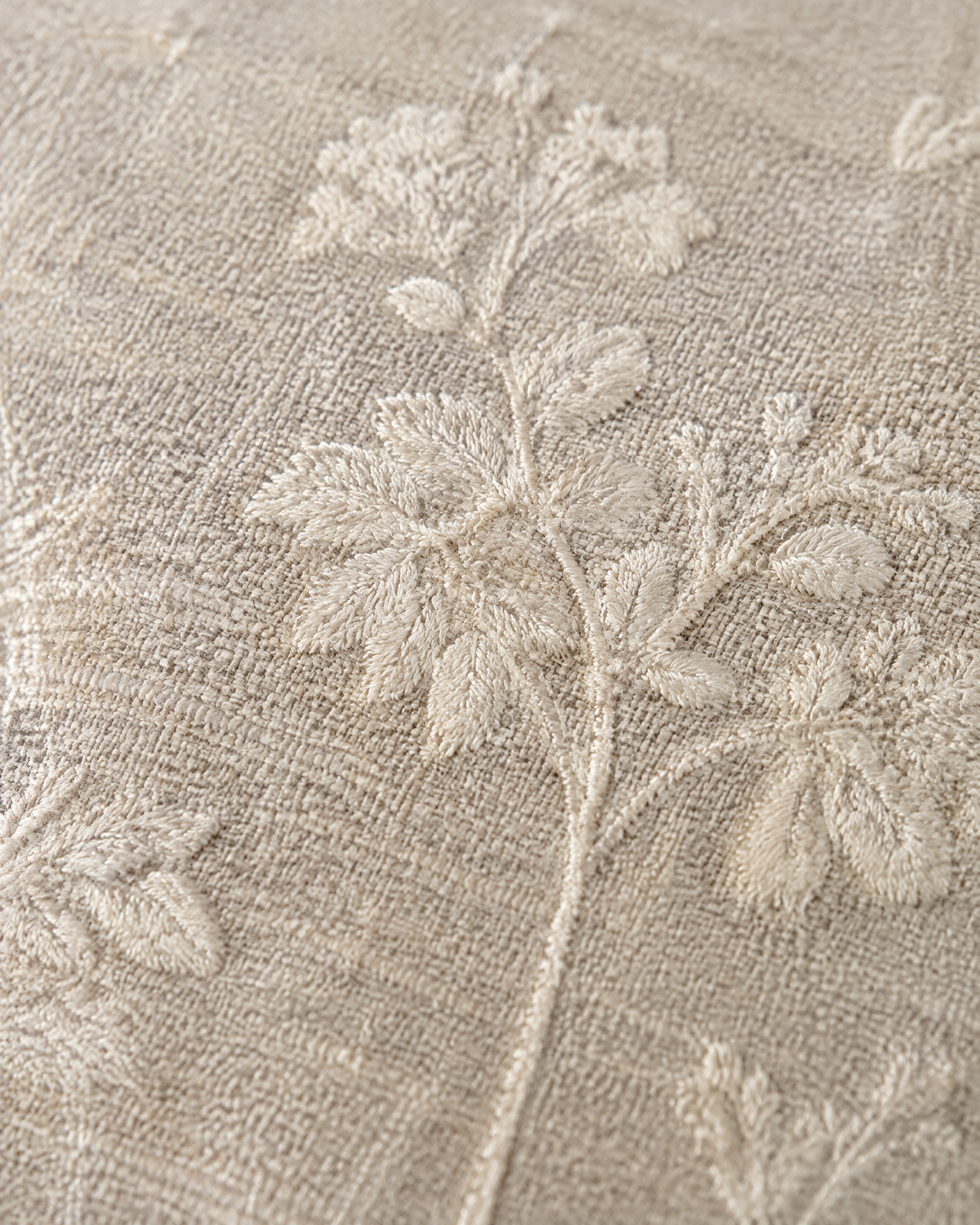 Close-up of ivory sprig embroidery on oat linen