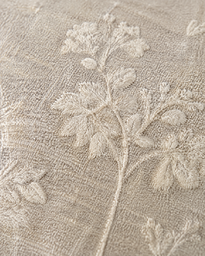 Close-up of ivory sprig embroidery on oat linen