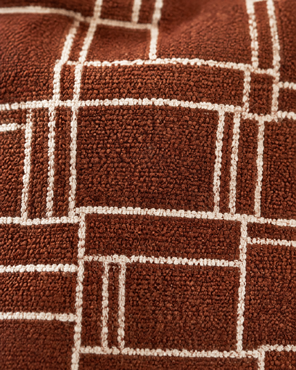 Close-up of rust chenille with ivory grid pattern