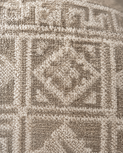Macro close-up of the sand geometric jacquard, Miao-style frets and diamonds woven in ivory and taupe