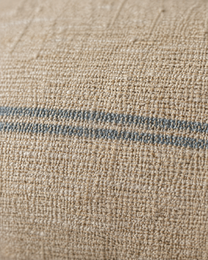 Macro close-up of a thin sky-blue woven stripe on slubbed sand hemp-cotton