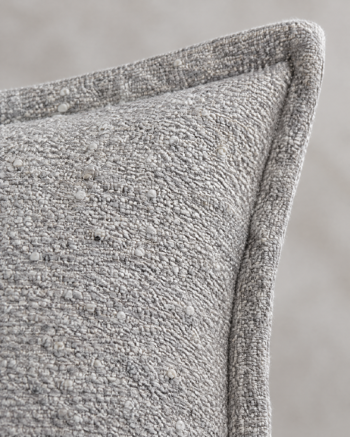 Macro close-up of the silver grey flecked jacquard, small ivory knots in a nubby grey weave with the flange