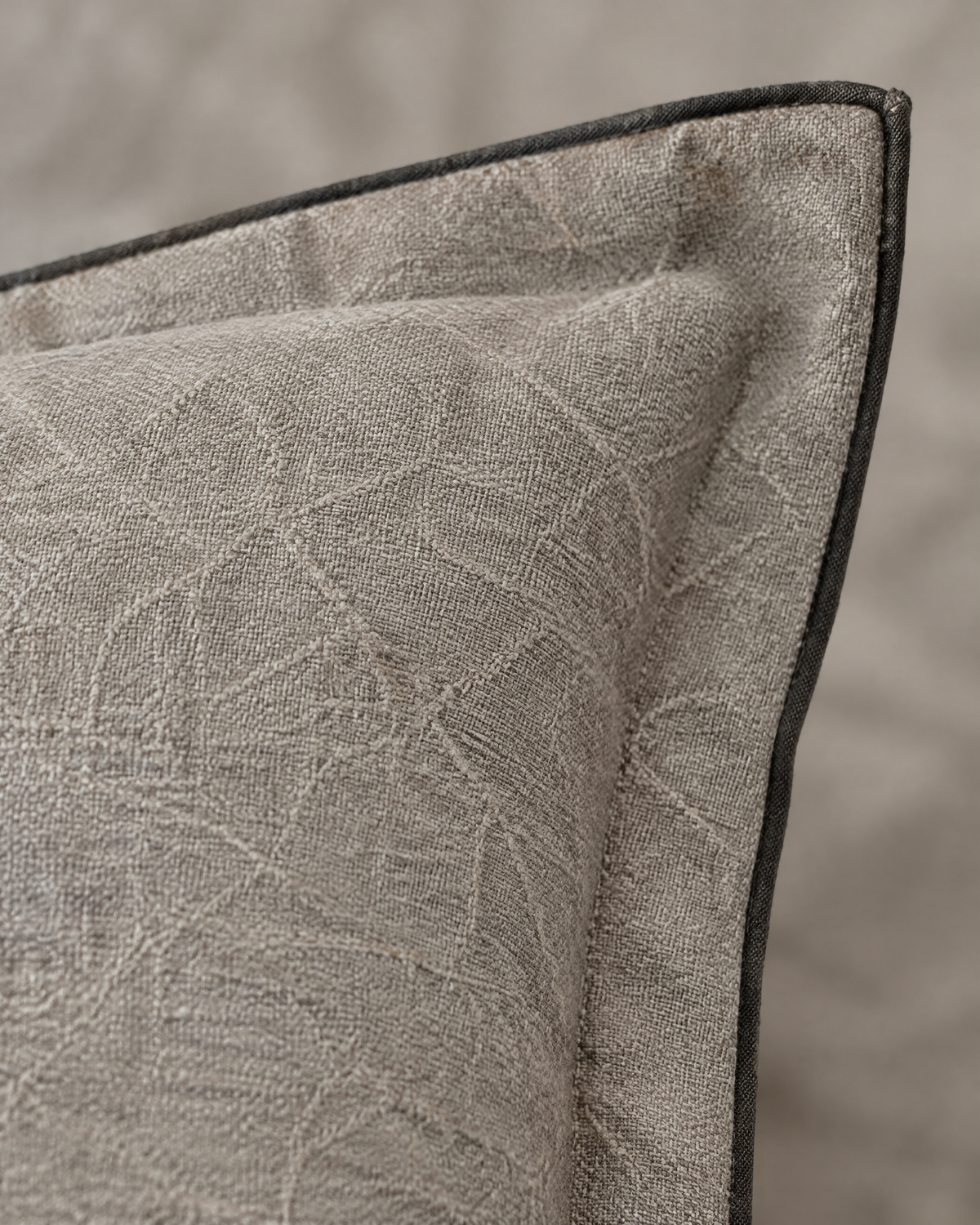 Macro close-up of the stone flanged jacquard, a faint crackle weave on stone linen with a thin charcoal binding