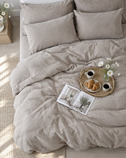 Greige cloud cotton duvet cover seen from above with a breakfast tray of coffee and croissants