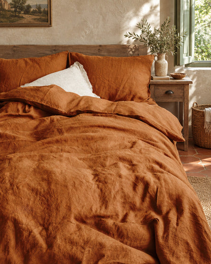 Terracotta French linen duvet cover and pillows, styled in a relaxed European country-house bedroom