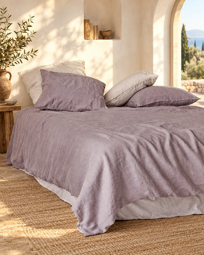 Pale mauve-grey French linen duvet cover, styled in a sun-washed Mediterranean bedroom
