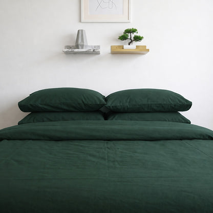 Forest Green plain cotton pillowcases and duvet cover in deep bottle green, front view of the bed