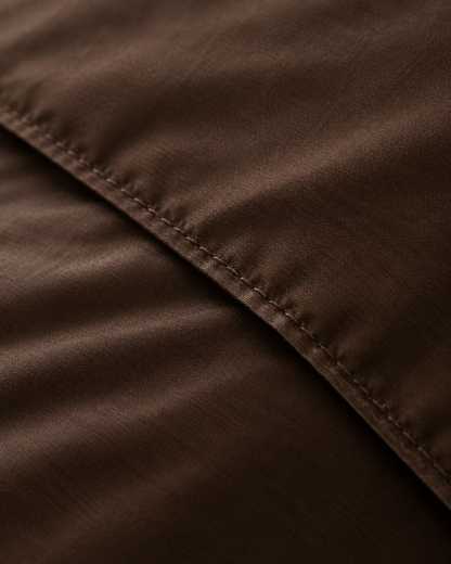 Macro of the stitched hem on a Chocolate silky cotton duvet cover, showing the weave.