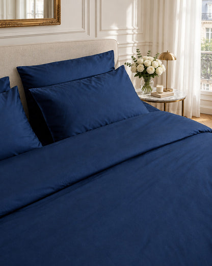 Navy silky cotton duvet cover, styled in an elegant Parisian apartment bedroom