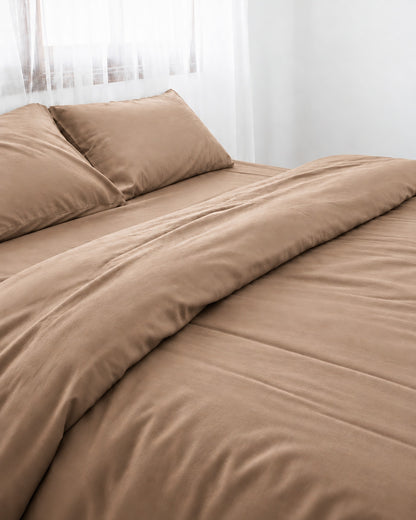 Light Beige silky cotton duvet cover, beige 300 TC cotton sateen, turned back on a bed by a white sheer curtain