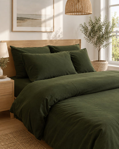 Forest green plain cotton pillows and duvet, styled in a bright modern townhouse bedroom