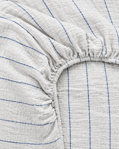 Close-up of elasticated corner and stitched edge of the fitted sheet in Blue Pinstripe Cloud Cotton