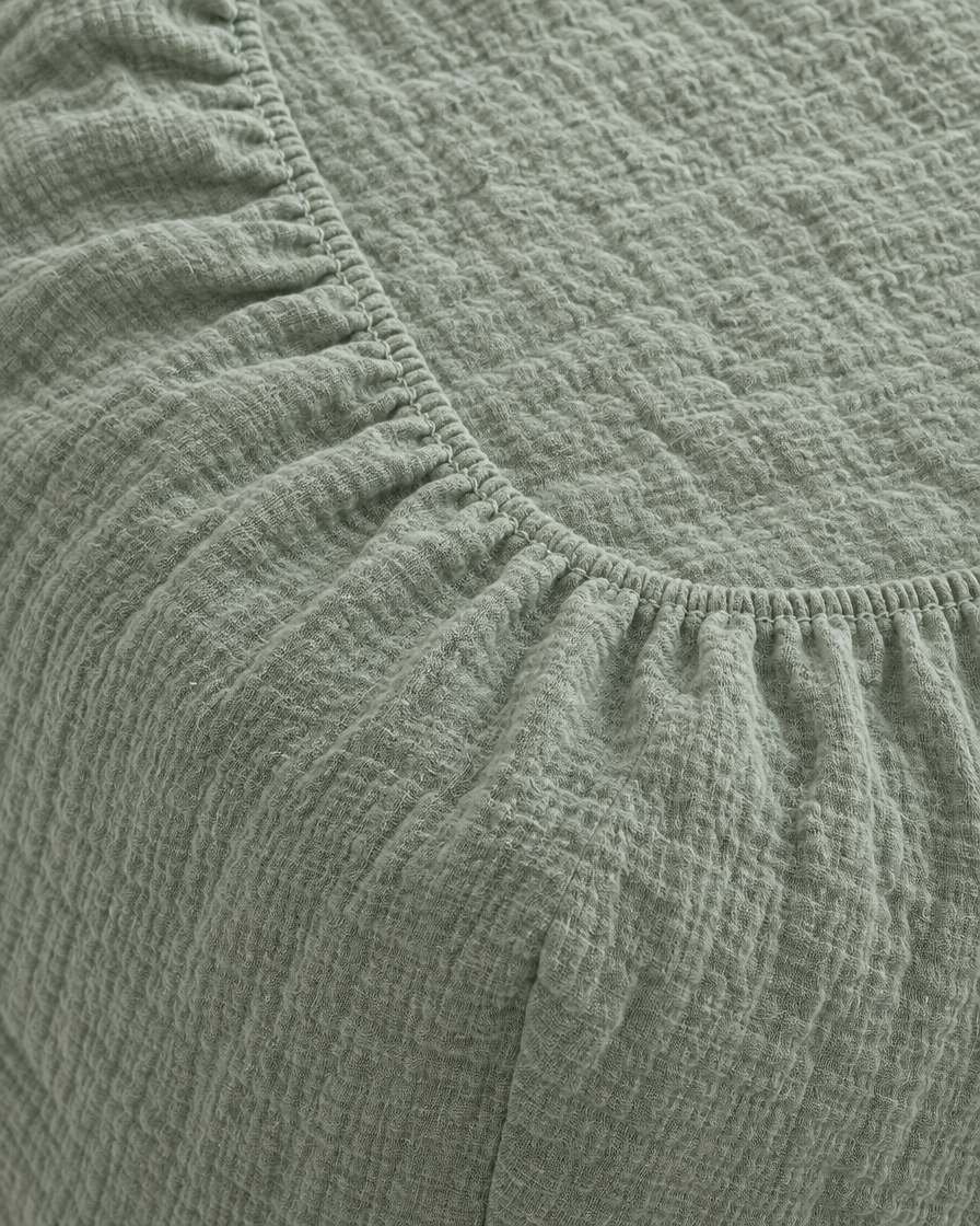 Close-up of elasticated corner and stitched edge of the fitted sheet in Mint Green Cloud Cotton