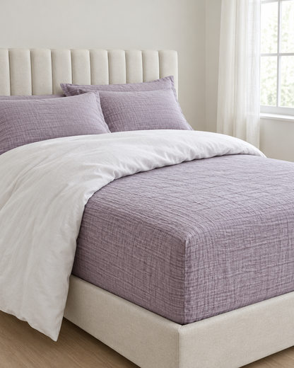 Taro Fitted Sheet - Cloud Cotton made up on a bed in a calm, light bedroom