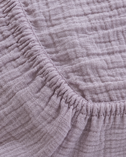 Close-up of elasticated corner and stitched edge of the fitted sheet in Taro Cloud Cotton
