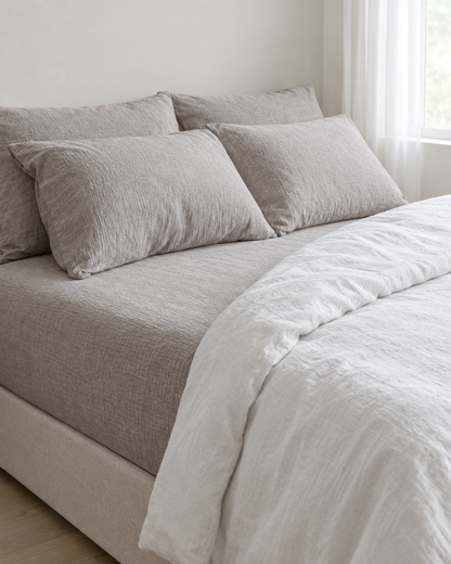 Warm Grey Fitted Sheet - Cloud Cotton made up on a bed in a calm, light bedroom