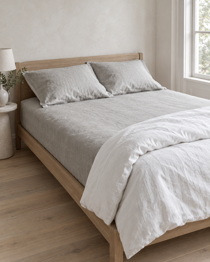 Pale silver-grey French linen fitted sheet and pillows in a light, airy bedroom