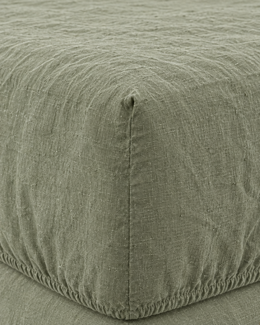 Close-up of elasticated corner and stitched edge of the fitted sheet in Sage Linen
