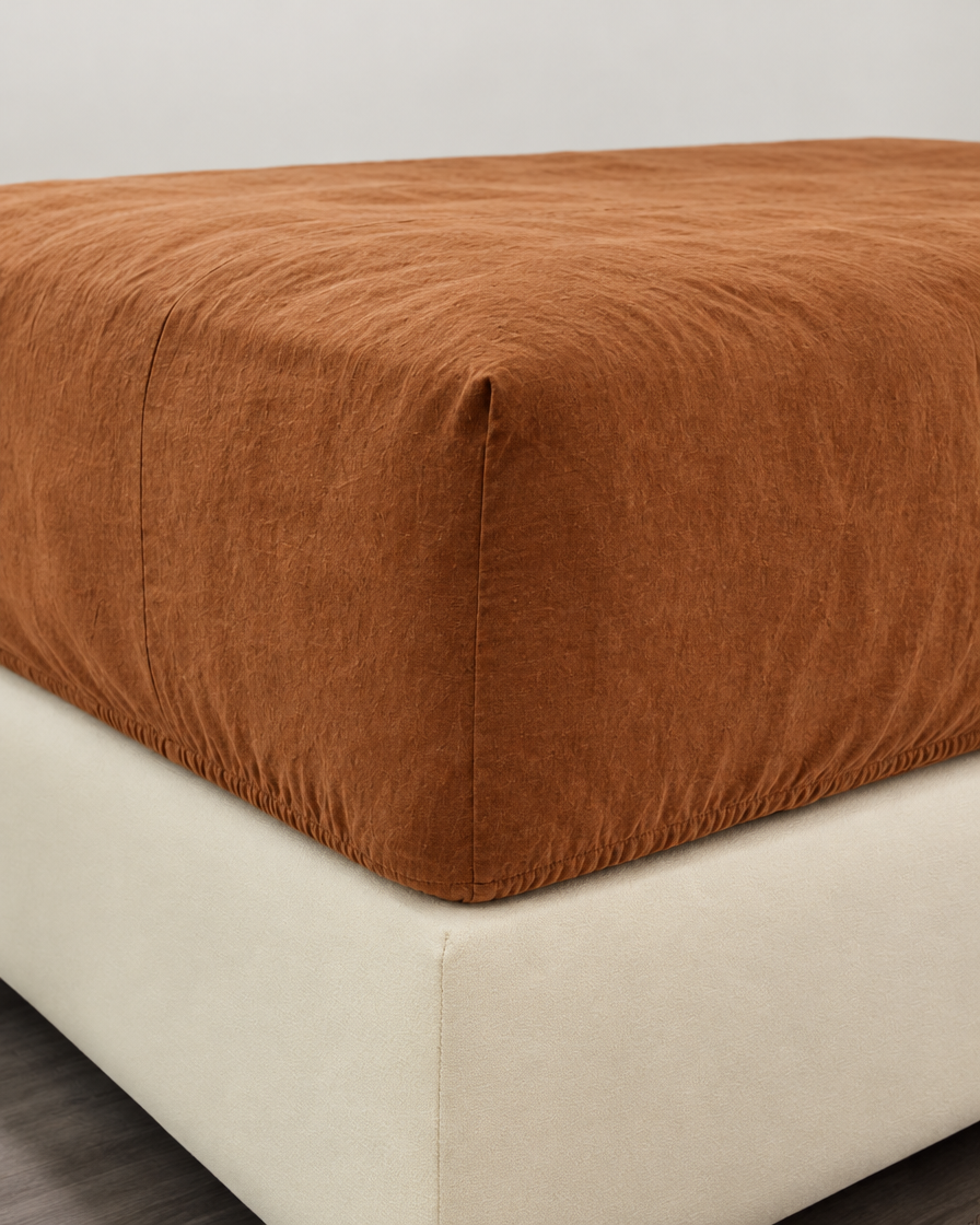 Terracotta French linen fitted sheet on a mattress corner