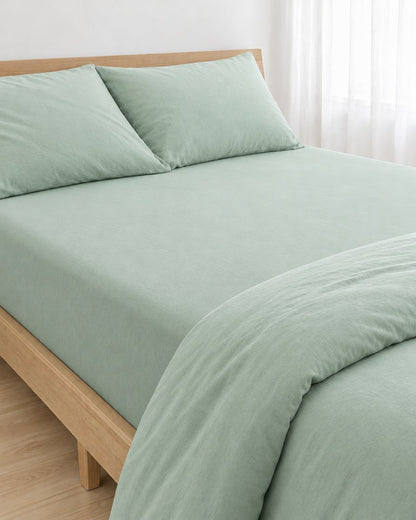 Mint Green plain cotton fitted sheet pulled taut over a mattress on an oak bed with matching pillowcases