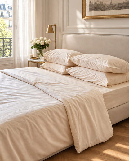 Cream and beige silky cotton bedding, styled in an elegant Parisian apartment bedroom
