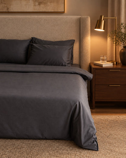 Charcoal grey silky cotton fitted sheet, styled in a boutique-hotel suite