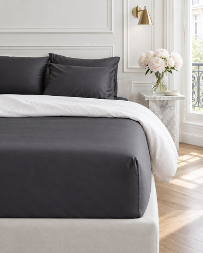 Charcoal Grey silky cotton fitted sheet in a Parisian bedroom with panelled walls and fresh peonies