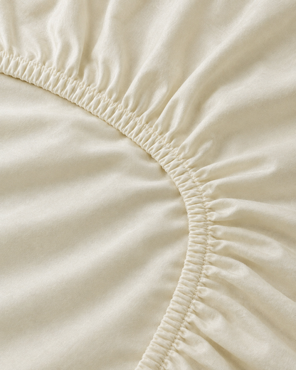 Close-up of elasticated corner and stitched edge of the fitted sheet in Vanilla Silky Cotton