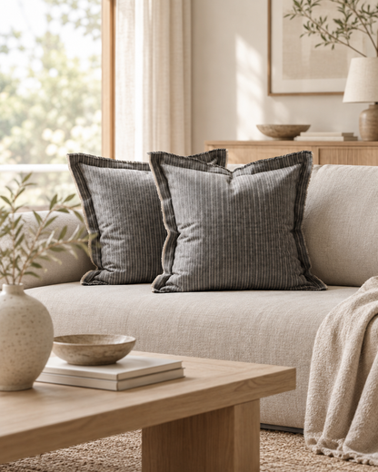 Grey pinstripe flanged cushions on a sofa in a Japandi lounge with a low oak table