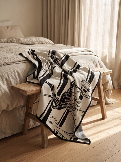 Swallow Jacquard Combed Cotton Knit Throw draped over a bench at the end of a bed