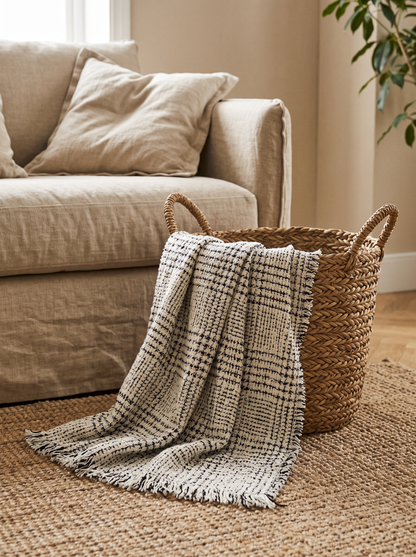 Grey Plaid Wool Blend Throw Blanket in a seagrass basket by the sofa