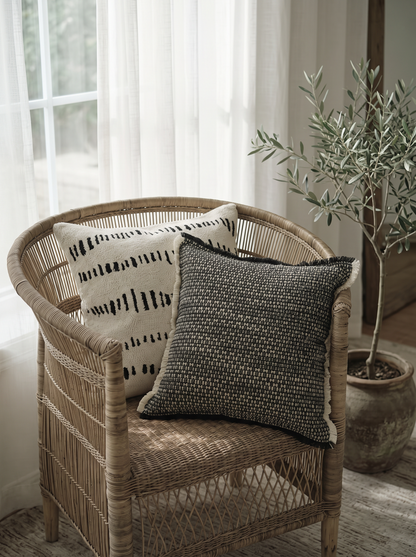 Ivory & Black Brushstroke Loop-Pile Embroidery Cotton Cushion Covers on a rattan armchair by a window