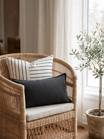 Ivory & Black Jacquard Stripe Linen Cotton Cushion Covers on a rattan armchair by a window