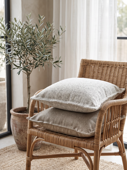 Grey Flanged Jacquard Cushion Covers on a rattan armchair by a window