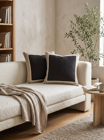 Framed Border Jacquard Cushion Covers in Black & Linen, styled at home on a bouclé daybed