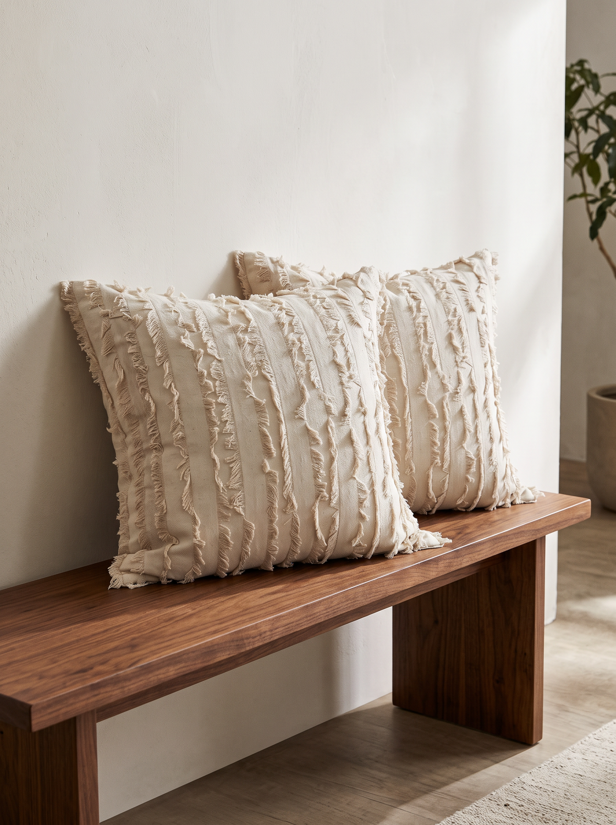 Camellia Embroidery and Fringed Jacquard Cushion Covers in Natural Fringed, styled at home on a walnut bench
