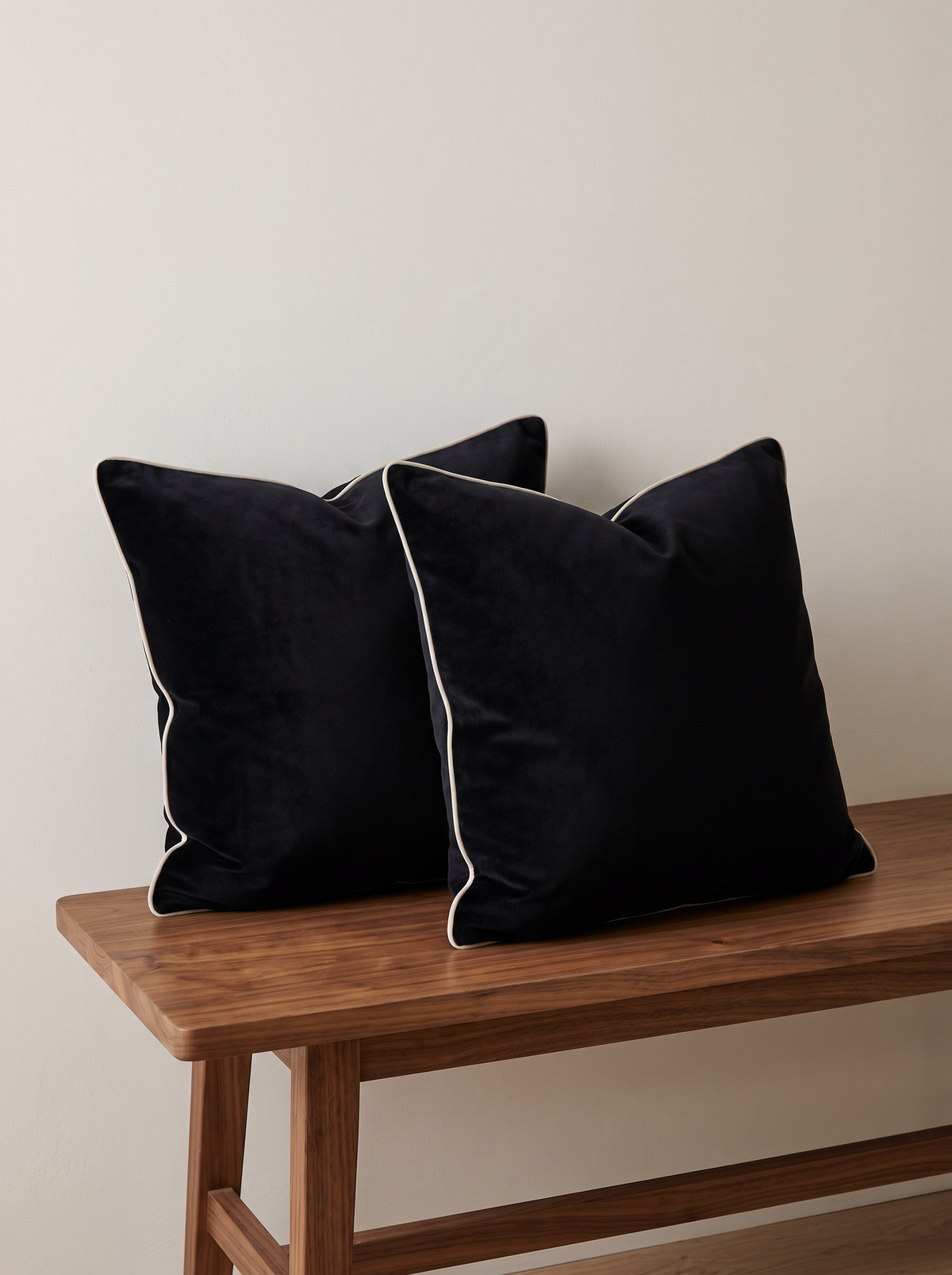 Piped Soft-Touch Cushion Covers in Ink, styled at home on a walnut bench
