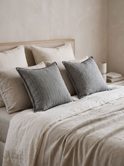 Herringbone Cotton Linen Cushion Covers in Rock Black, styled at home on a made bed