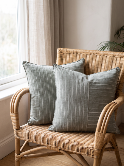 Pinstripe Panel Linen Cushion Covers in Olive Green, styled at home on a rattan armchair by a window