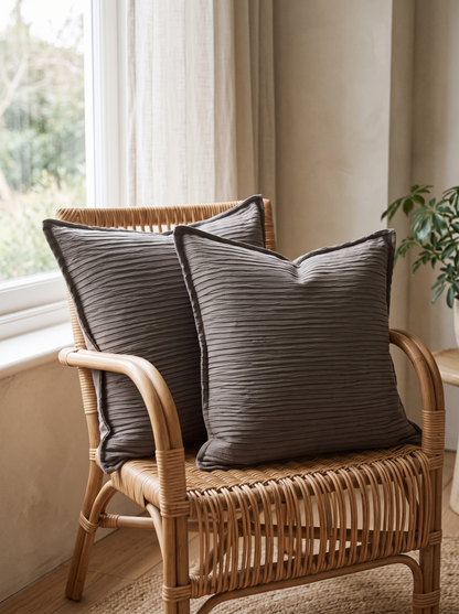 Ribbed Jacquard Cotton Cushion Covers in Dark Coffee, styled at home on a rattan armchair by a window