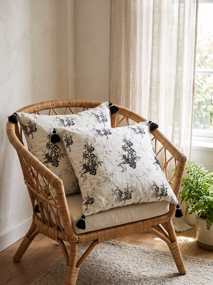 Ivory & Charcoal Botanical Jacquard Cotton Linen Cushion Covers, styled at home on a rattan armchair by a window