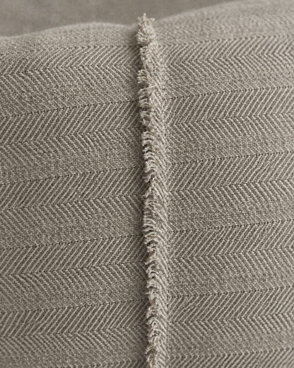 Macro close-up of the stone herringbone jacquard and its single frayed raised seam