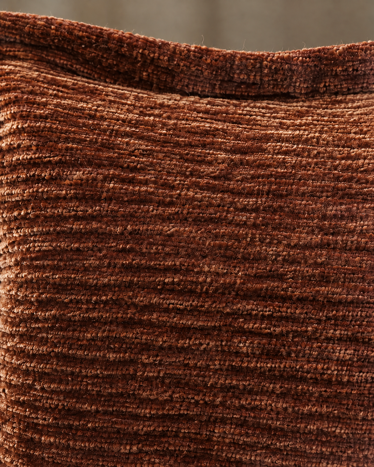 Macro close-up of rust washed velvet, crushed copper pile in irregular corded ribs below the flat flange edge