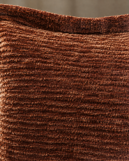 Macro close-up of rust washed velvet, crushed copper pile in irregular corded ribs below the flat flange edge