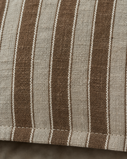 Macro close-up of Brown Stripe woven linen, cocoa and greige stripes with slubbed yarns above the topstitched flange
