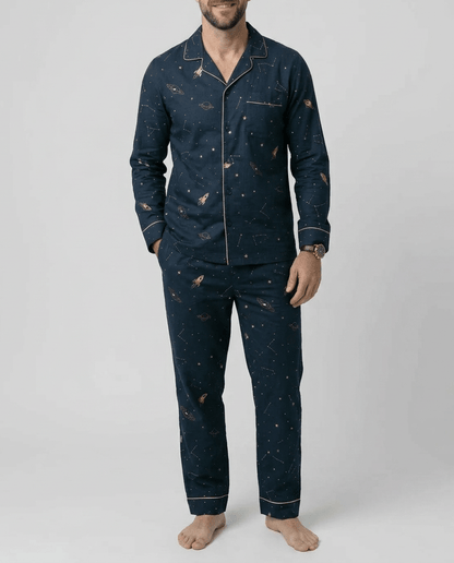 Man wearing a navy blue pajama set with star pattern on a white background