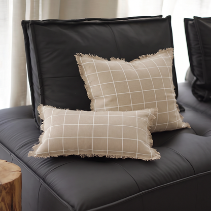 Natural Check Jacquard cushion covers in White Grid, square and lumbar, on a black leather sofa